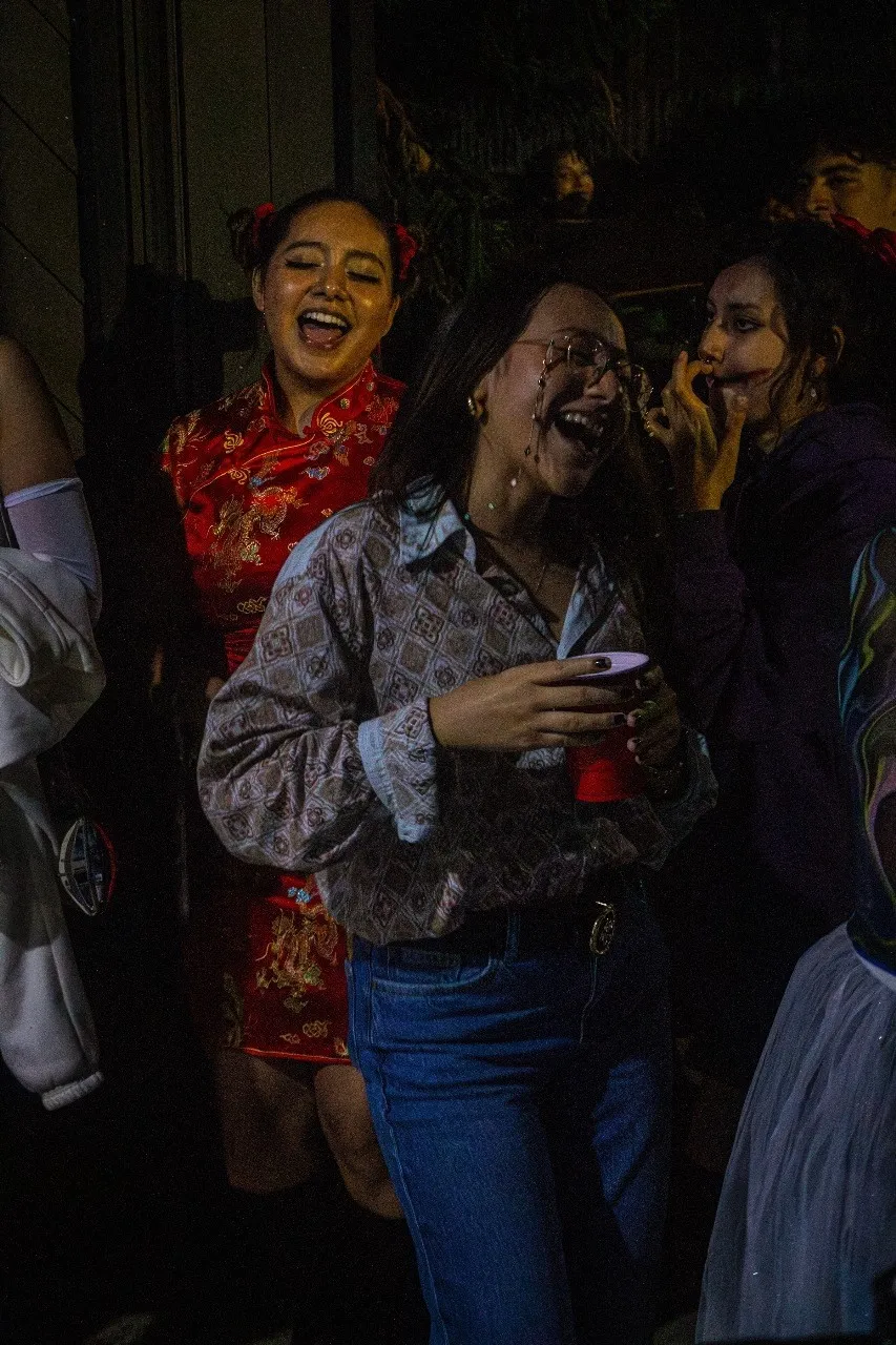 Invitadas disfrazadas riendo con sus bebidas